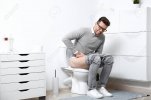 137173239-man-with-stomach-ache-sitting-on-toilet-bowl-in-bathroom.jpg